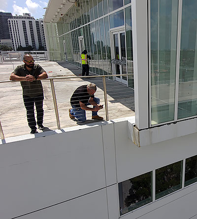 Two men from Building Mavens review building safety information on the roof of a condo Two men from Building Mavens review building safety information on the roof of a condo