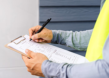 Building inspector reviews a checklist on a clipboard.