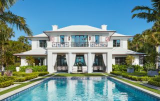 Back of a luxurious Anglo-Caribbean home in Hobe Sound, Florida on a sunny, cloudless day.