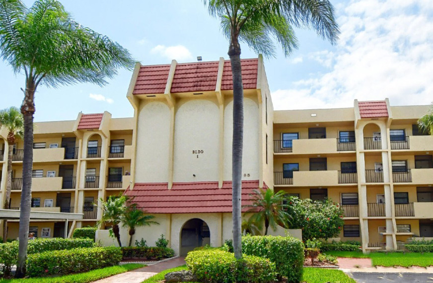 Exterior view of Barwood condominium building with palm trees in Florida.